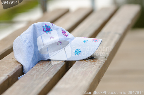 Image of Forgotten cap girl lying on a bench