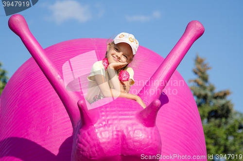 Image of Moscow, Russia August 10, 2015: Six-year girl on a pink snail, exhibit ENEA in Moscow