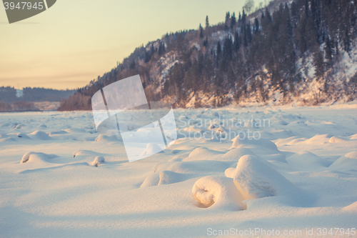 Image of winter landscape of snow-covered fields, trees 