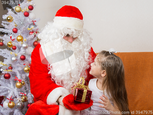 Image of Santa Claus gives a gift a five-year girl