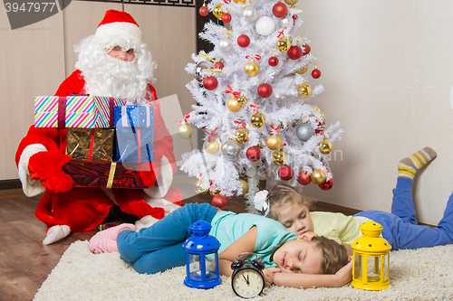 Image of Santa Claus brought gifts for New Year\'s Eve and softened faces of the two sleeping sisters