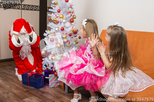 Image of Two girls saw Santa Claus who brought them gifts