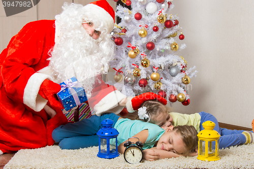 Image of Santa Claus brought gifts, pats on the head of sleeping children, and looked into the frame