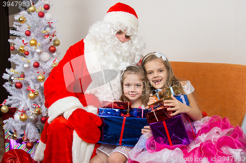 Image of Santa Claus gave presents to the children and hugged