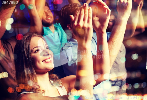 Image of smiling friends at concert in club