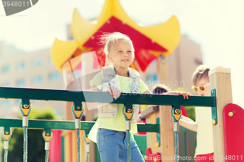 Image of happy little girl climbing on children playground