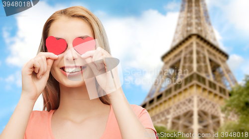 Image of happy young woman with red heart shapes on eyes