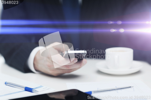 Image of businessman with smartphone reading news