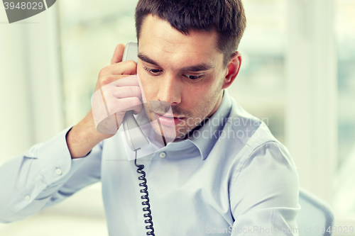 Image of face of businessman calling on phone in office