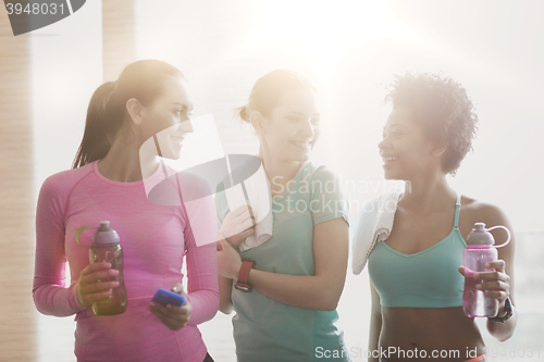 Image of happy women with bottles of water in gym