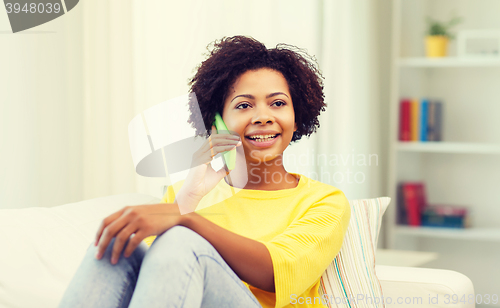 Image of happy african woman with smartphone at home