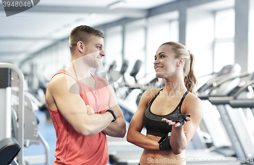 Image of smiling man and woman talking in gym