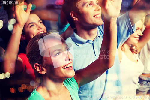 Image of smiling friends at concert in club