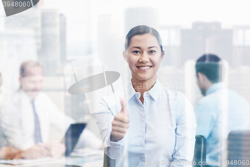 Image of group of smiling businesspeople meeting in office