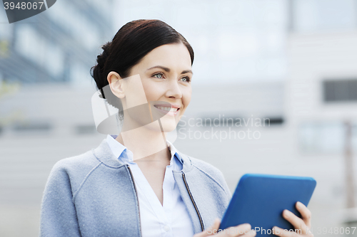 Image of smiling business woman with tablet pc in city