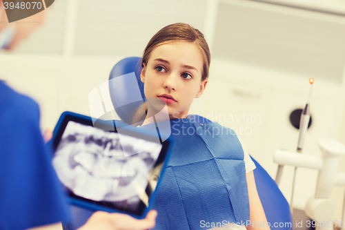 Image of dentist with x-ray on tablet pc and girl patient