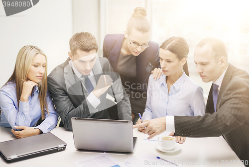 Image of business team with laptop having discussion