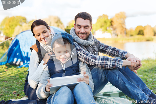 Image of happy family with tablet pc and tent at camp site