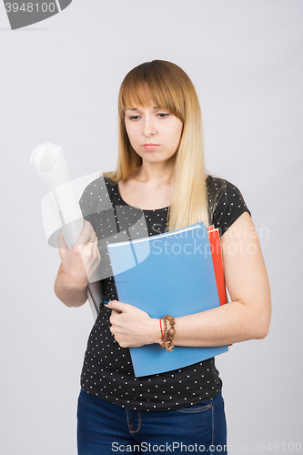 Image of Half-length portrait of a young girl with folders and a roll of paper in his hands