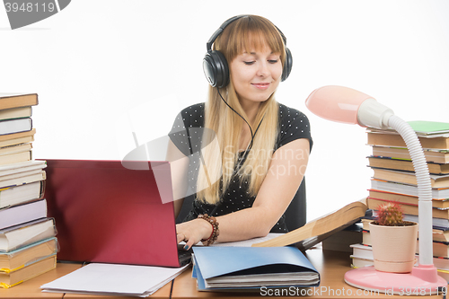 Image of Student headphones preparing writing course project in electronic form