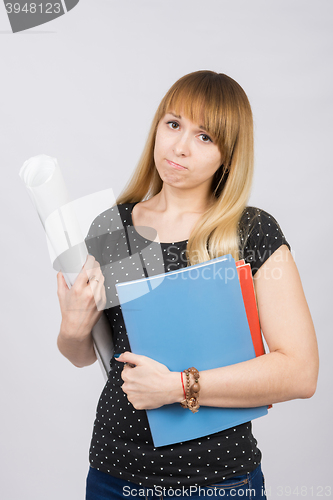 Image of Young girl student with a project in hand and angrily looks into the frame