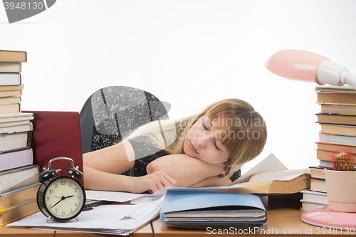 Image of Student fell asleep at the table getting ready to pass the graduation project