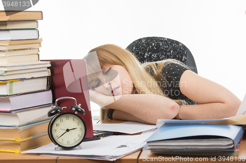 Image of Student fell asleep at his desk preparing for an exam