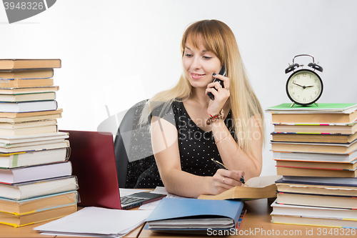 Image of A student preparing for exams and talking on the phone