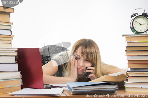 Image of Tired student late at night talking on the phone