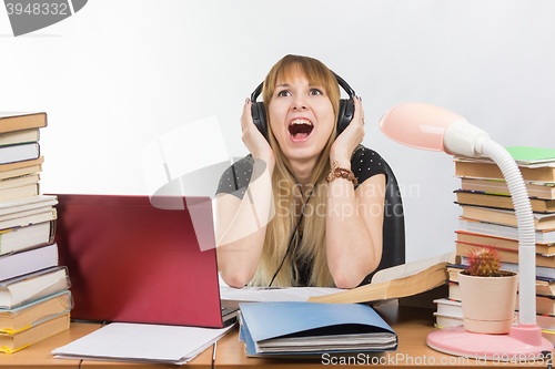 Image of A student shouts from fatigue while listening to music on headphones