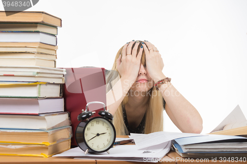 Image of Student covering her eyes with her hands to take a break from their studies