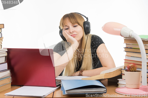 Image of Student thinking and looking with interest at a laptop