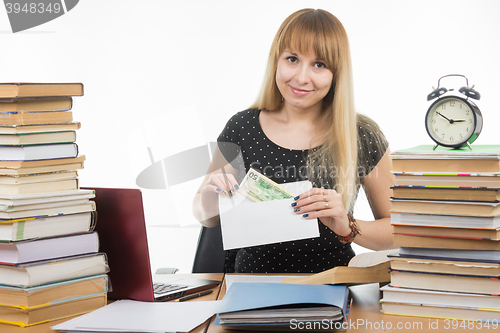Image of The girl puts money in an envelope to bribe the teacher in the exam, and looked into the frame