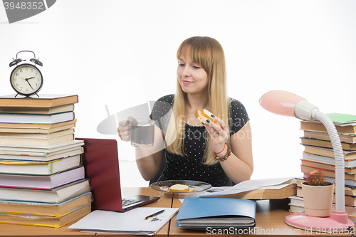 Image of Sleepy student bites sandwich with coffee