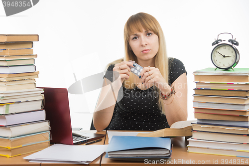 Image of Diseased student sitting at the table with tablets in hands