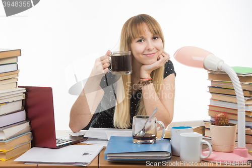 Image of Student drinking another cup of coffee by preparing for the exam at night