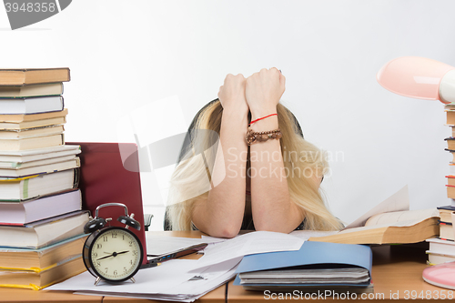 Image of Student covering her head arms in preparation for exams