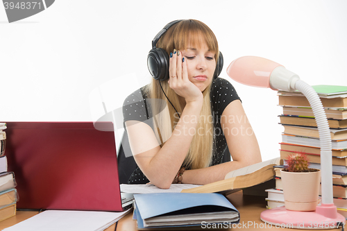 Image of Student falling asleep reading a reference book