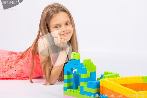 Image of Seven-year girl builds a house from the block designer and thoughtful and fun looks in the frame