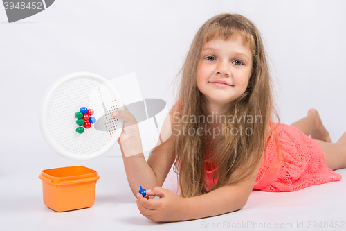 Image of Girl shows a mosaic with unfinished flower