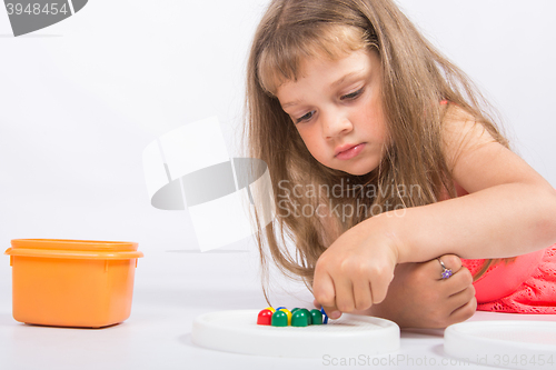 Image of Concentrated girl collects mosaic