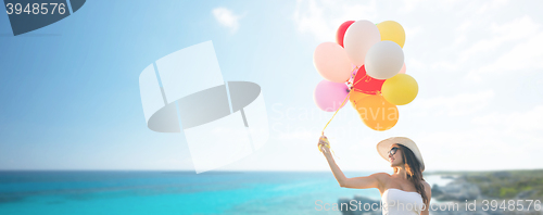 Image of smiling young woman in sunglasses with balloons