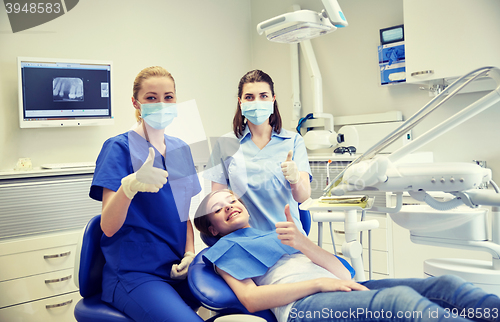 Image of happy female dentist with patient girl at clinic