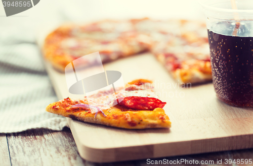 Image of close up of pizza with carbonated drink on table