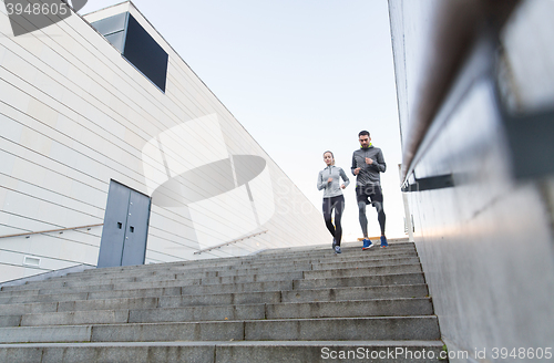 Image of couple running downstairs on city stairs