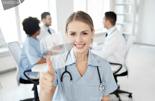 Image of happy doctor over group of medics at hospital