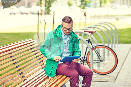 Image of happy young hipster man with tablet pc and bike