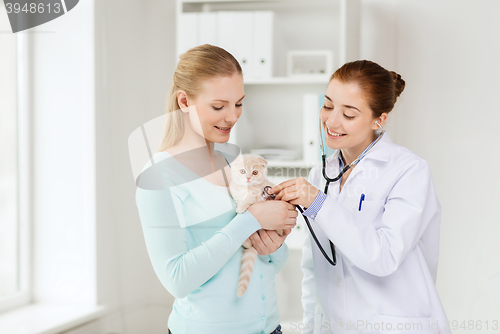 Image of happy woman with cat and doctor at vet clinic