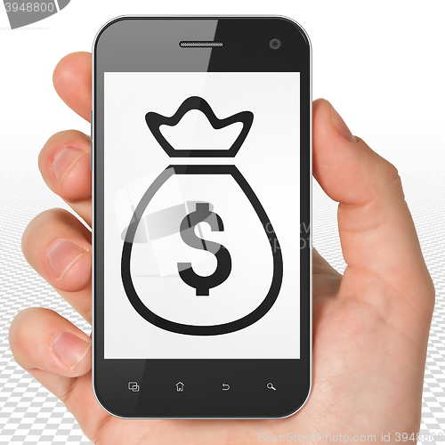 Image of Banking concept: Hand Holding Smartphone with Money Bag on display