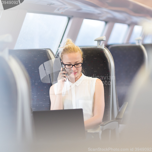 Image of Business woman working while travelling by train.